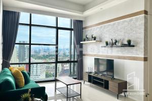 a living room with a green couch and a large window at 1-5 Guests, 2BR Family Home, Azure Residences PJ-Beside Paradigm Mall - Flexihome MY in Petaling Jaya