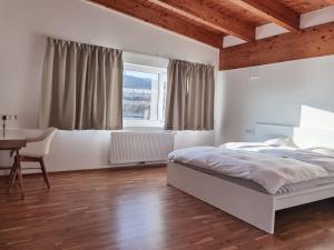 Schlafzimmer mit einem Bett, einem Schreibtisch und einem Fenster in der Unterkunft BeeHome Apartment in Purkersdorf