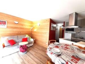 eine Küche und ein Wohnzimmer mit einem Tisch und einem Sofa in der Unterkunft Appartement Saint-Lary-Soulan, 2 pièces, 6 personnes - FR-1-457-144 in Saint-Lary-Soulan