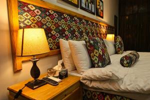 a bedroom with a bed and a lamp on a table at Oak Residency in Gilgit