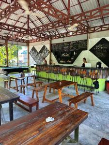 a restaurant with wooden tables and a bar with a pool table at Nest Jungle in Kaôh Rŭng (3)