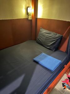 a small bed with a blue pillow on it at Nest Jungle in Kaôh Rŭng (3)
