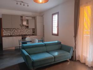 Il comprend un salon avec un canapé bleu et une cuisine. dans l'établissement Appartamento al Globo, à Busnago