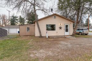 a small house with a tree in a yard at Choteau Vacation Rental with Yard Walk to Downtown! in Choteau