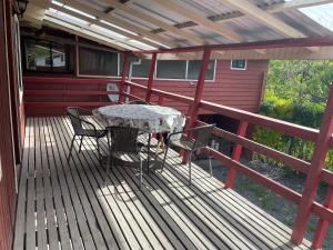 un patio con mesa y sillas en una terraza en Aparamentos Los Notros Neltume Huilo Huilo, en Neltume