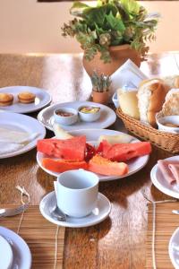una mesa con platos de comida y una taza de café en Pousada Praias do Norte, en São Miguel dos Milagres
