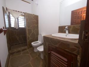 uma casa de banho com um lavatório, um WC e um chuveiro em Beach Way Villa em Malindi