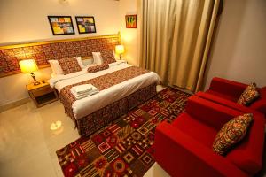 Habitación de hotel con cama y sofá rojo en Oak Residency, en Gilgit