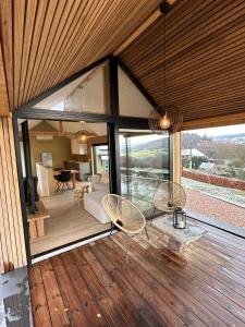 una sala de estar con sillas y una sala de estar con ventanas en Le petit gîte de Borgoumont à Stoumont, en Stoumont