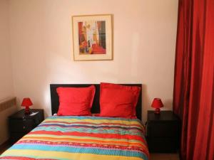 um quarto com uma cama com duas almofadas vermelhas em Appartement Ajaccio, 3 pièces, 6 personnes - FR-1-61-564 em Ajaccio