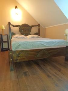 uma cama com uma estrutura de madeira num quarto em Pensjonat Wiking em Stare Jabłonki