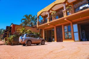 a car parked in front of a building at GOLDEN QUEST HOTEL in Entebbe