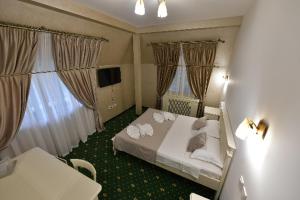 Un pat sau paturi într-o cameră la Hotel Restaurant Casa Cu Tei Craiova