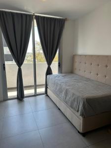 a bedroom with a bed and a large window at Em Departamento Amoblado Cordoba in Cordoba