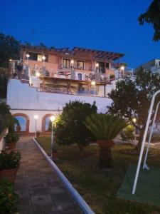 duży dom z ludźmi na balkonie w nocy w obiekcie Garden on the Sea w mieście Vico Equense