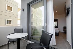 una camera con tavolo, sedie e finestra di EcoHeaven Suites ad Amoudara Herakliou