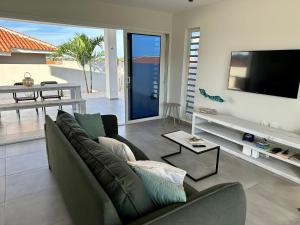 a living room with a couch and a flat screen tv at Villa Vista Montaña in Willemstad