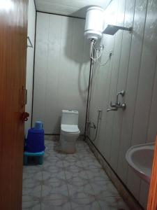 a small bathroom with a toilet and a sink at Badrinath Jbk by Prithvi Yatra Hotel in Badrīnāth