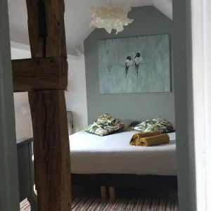 a bedroom with a bed with two birds on the wall at une maison à la campagne in Beaune-la-Rolande