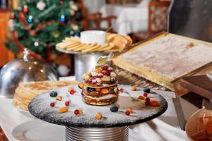 バンスコにあるPirin Golf Hotel & Spaのクリスマスの木の前のテーブルに並ぶデザート