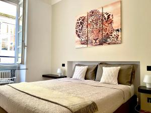 ein Schlafzimmer mit einem Bett und zwei Gemälden an der Wand in der Unterkunft CHARMING COMO - Apartment downtown in the pedestrian area with 2 double bedrooms and 2 complete bathrooms a spacious living room and full equipped kitchen in Como
