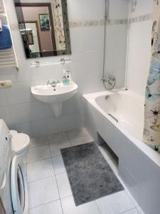 a bathroom with a sink and a tub and a toilet at Apartment with city history in the center in Dnipro
