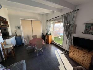 Televízia a/alebo spoločenská miestnosť v ubytovaní T2 cabine avec terrasse, parking et animaux acceptés à 100m de la plage - FR-1-702-38