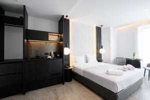 una camera da letto con un letto con lenzuola bianche e un tavolo di EcoHeaven Suites ad Amoudara Herakliou