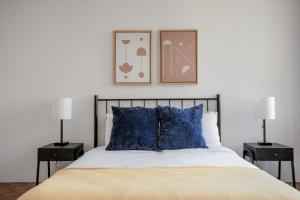 a bedroom with a bed with blue pillows and two lamps at Back Bay 1br w gym rooftop nr shopping BOS-926 in Boston