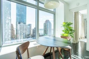 a dining room with a table and chairs and a large window at Financial District 1br w WD gym elevator NYC-1362 in New York
