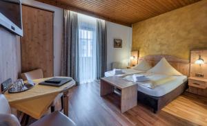a hotel room with a bed and a table at König Ludwig Stub´n in Prien am Chiemsee