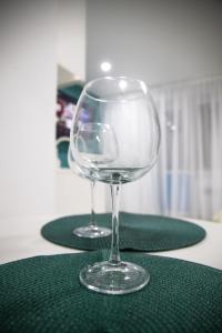 dos copas de vino vacías sentadas en dos servilletas verdes en Апартаменты в ЖК Каркын, en Kostanái