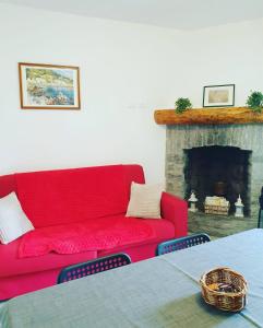 a red couch in a living room with a fireplace at Ca' Sunin Bellagio - mountains view apartment in Bellagio