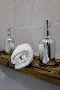 un vassoio di legno con un asciugamano e una bottiglia di sapone di Апартаменты в ЖК Каркын a Qostanay