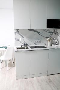 una cucina bianca con lavandino e piano cottura di Апартаменты в ЖК Каркын a Qostanay