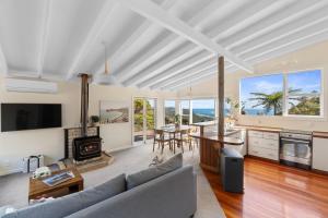 a living room with a couch and a table at Piha - City Escape, Piha Holiday Home in Piha
