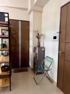 um quarto com uma cadeira, uma porta e um frigorífico em Spacious Unit with City View at Iloilo Business Park em Iloilo