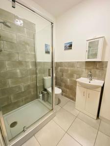 a bathroom with a shower and a toilet and a sink at Portland View - Spacious & Comfortable in Weston