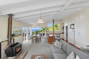 a living room with a couch and a fireplace at Piha - City Escape, Piha Holiday Home in Piha