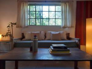 a living room with a couch with a table and a window at Casa.Colibri.LaCumbre in La Cumbre