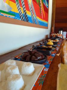 Pousada Pedra Alta في إيتاكاري: طاولة طويلة عليها أنواع مختلفة من الطعام