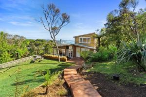 a house with a garden and a walkway at Piha - City Escape, Piha Holiday Home in Piha