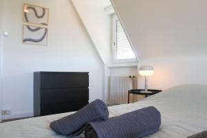 1 dormitorio con 1 cama con zapatillas de color púrpura en {L'Essentiel}, calme, proche autoroute en Mulhouse