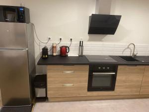 eine Küche mit einem Kühlschrank und einer Arbeitsplatte in der Unterkunft Coeur de Jaude 2 chambres Tout équipé 4 personnes in Clermont-Ferrand