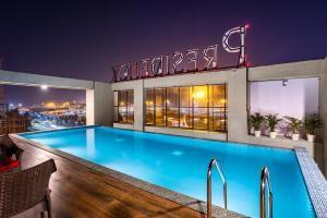 a swimming pool on top of a building at night at PRESIDENCY AIRPORT HOTEL in Cochin