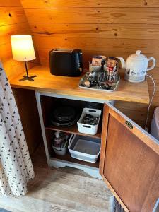 een kast met een magnetron en een lamp op een tafel bij Blackbrook lodge Camping pods in Belper