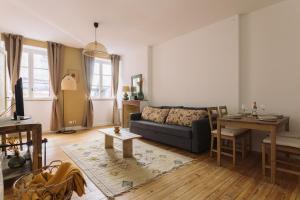 ein Wohnzimmer mit einem Sofa und einem Tisch in der Unterkunft By Homy in Bordeaux
