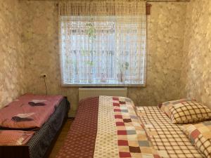 a bedroom with two beds and a window with curtains at House of Grace in Reni