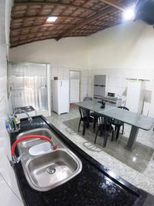 uma cozinha com um lavatório e uma mesa em Sítio Elo Perdido Guararema em Guararema