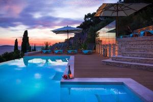 a swimming pool with a sunset in the background at Luxury Villa Hvar Carpe Diem with private pool by the sea in Hvar
